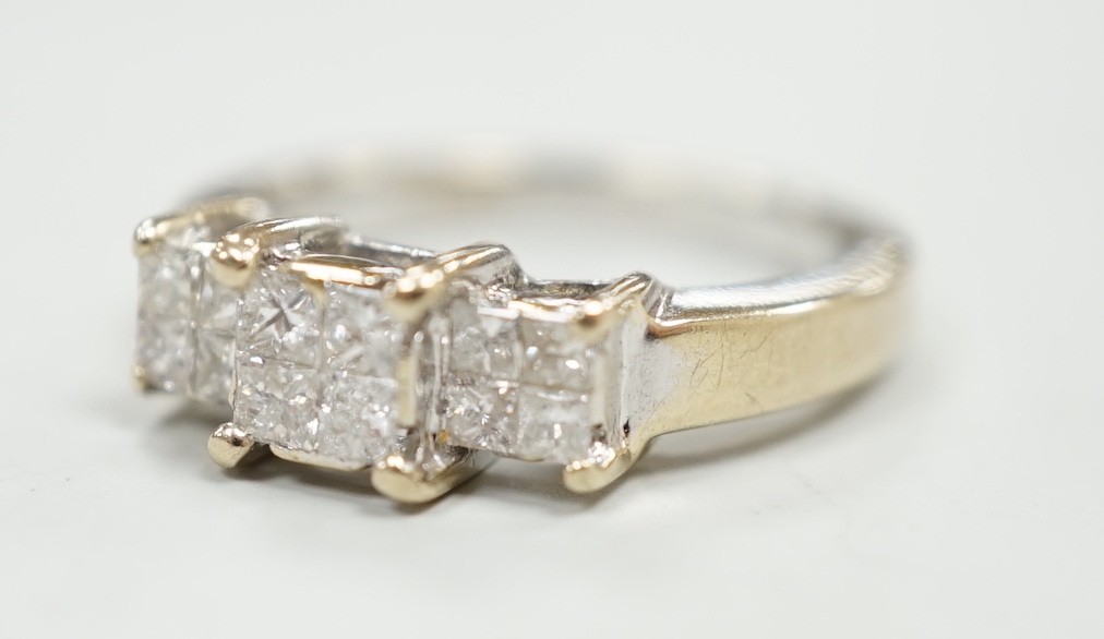 A modern 18ct white gold and triple princess cut diamond cluster set dress ring, size K, gross weight 5 grams.